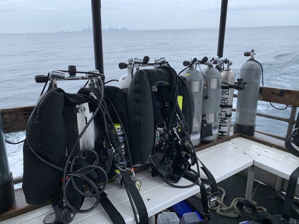Dive tanks staged on a boat deck with the Chicago skyline in the distance
