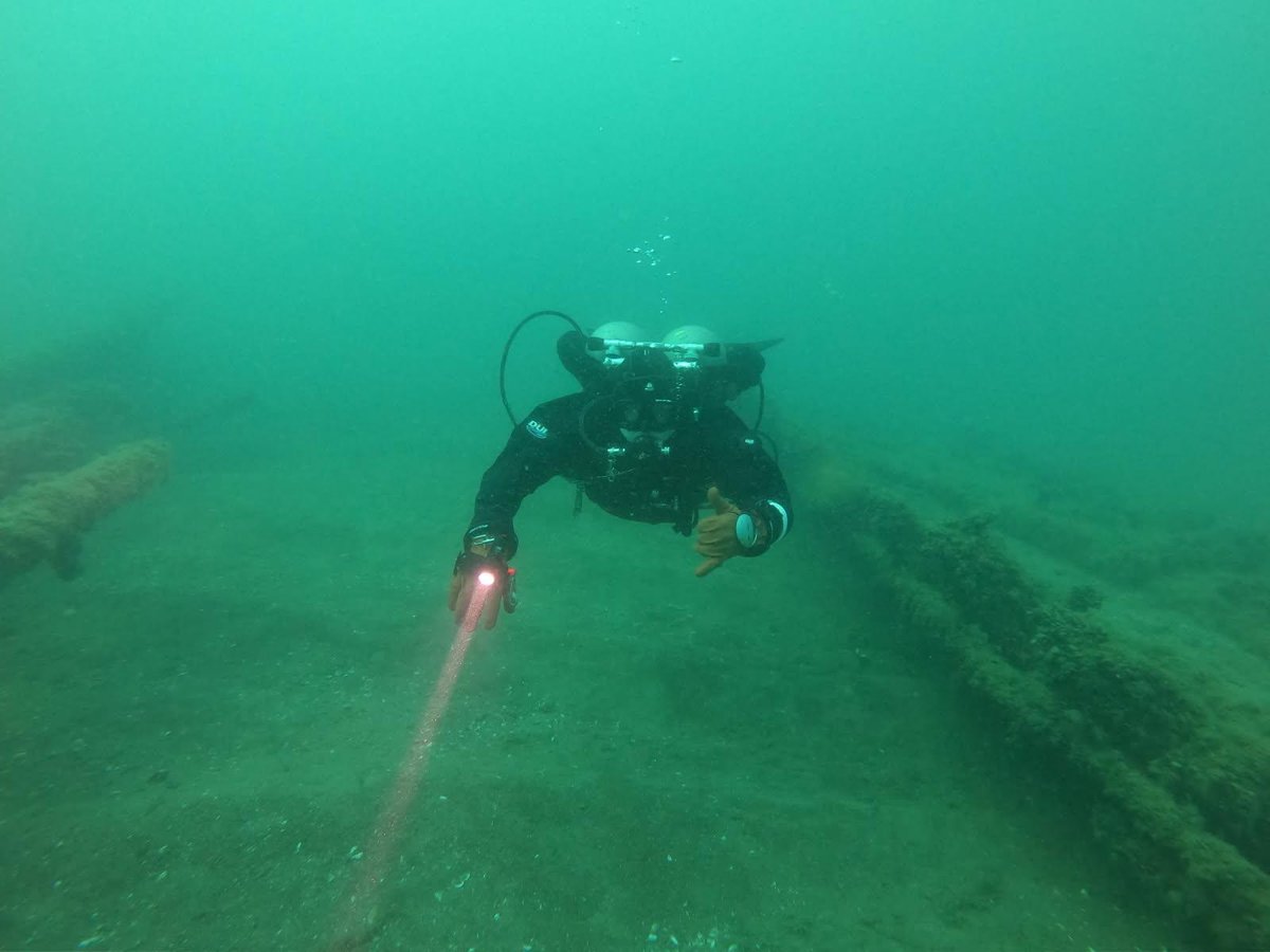 Diver giving an OK sign near a wreck